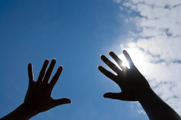 istock A hand held up to the blue sky. 2199052625