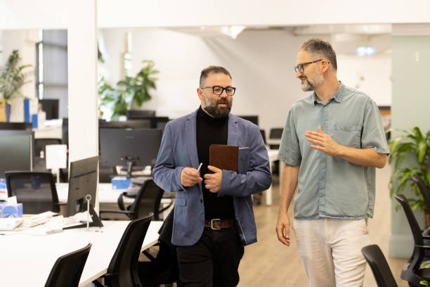 istock Two Professional Colleagues Discussing Ideas in a Modern Open Office Setting 2199053925