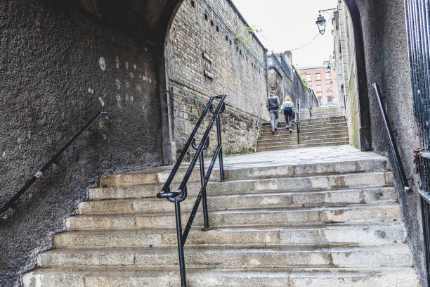 DUBLIN, IRELAND - SEPTEMBER 20, 2018: View of an old stone stairway in Dublin, leading up between historic buildings, with pedestrians walking ahead.