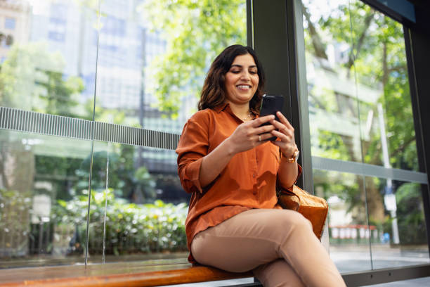 istock Woman Smiling While Using Smartphone in Urban Outdoor Setting 2199054347