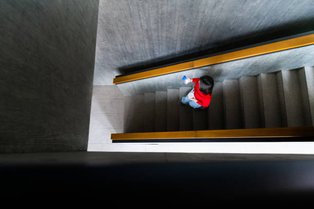 istock Young woman is walking downstairs in office building 2199061895