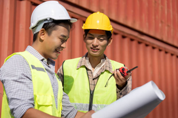 istock Engineers discussing logistics and construction plans with blueprints and a walkie-talkie. 2199061964