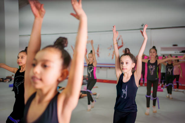 istock Young Gymnasts Practicing Ballet Poses in a Gymnastics Training Center 2199065317