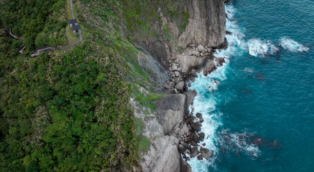 Visitors hike the Dashibishan Trail, enjoying breathtaking coastal views and lush greenery under a clear sky.