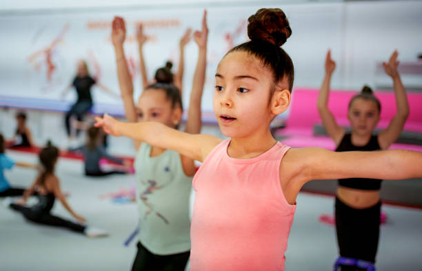 istock Young Gymnasts Practicing Ballet Poses in a Gymnastics Training Center 2199067416
