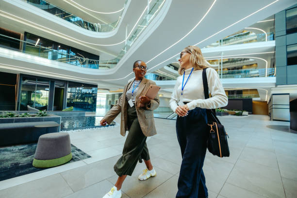 istock Two female colleagues walking and chatting in modern office space 2199071885