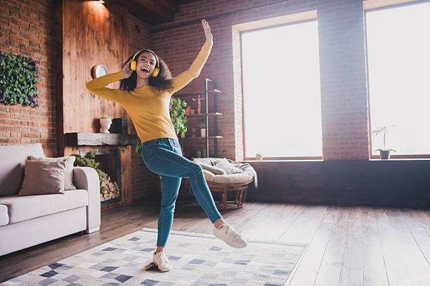 istock Young student dancing joyfully in cozy apartment with natural light and casual attire 2199076379