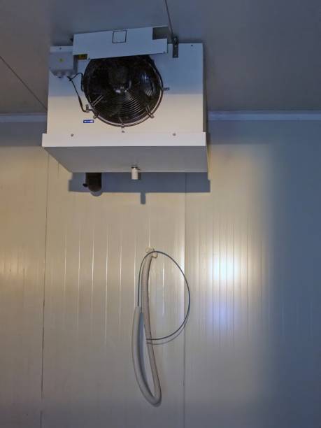 istock A ceiling-mounted commercial refrigeration unit cools a warehouse with a hanging hose on the wall. 2199076473
