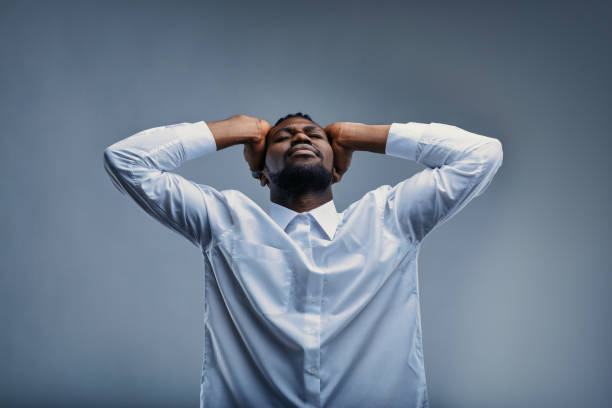 istock Stressed businessman holding head in hands with eyes closed 2199077001