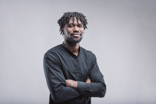 istock Confident young man with crossed arms and dreadlocks posing in studio 2199077200