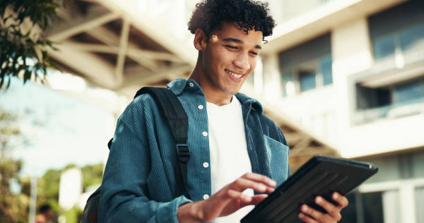 Tablet, happy student and man at university outdoor for class schedule, learning and online education. Smile, technology and person at college campus to check test results, research or reading ebook