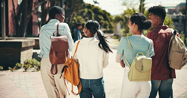 istock Back, education and walking with student friends outdoor together for learning or study at university. College, conversation and future with learner group at school for knowledge or scholarship 2199077238