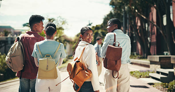 istock Back, future and walking with student friends outdoor together for learning or study at university. College, education and portrait with happy learner group at school for knowledge or scholarship 2199077239