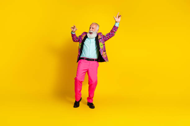 istock Photo of eccentric positive cool senior man dressed stylish bright clothes dance empty space isolated on yellow color background 2199079320