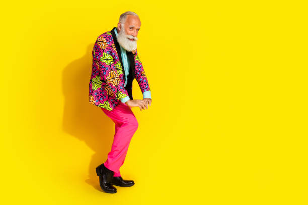 istock Full size photo of funky aged man dance perform empty space wear classy bright clothes isolated on yellow color background 2199079420