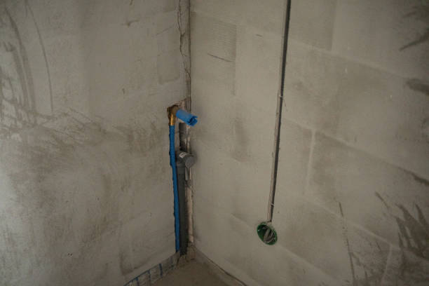 istock Water supply pipe installation in a concrete wall during construction 2199081234
