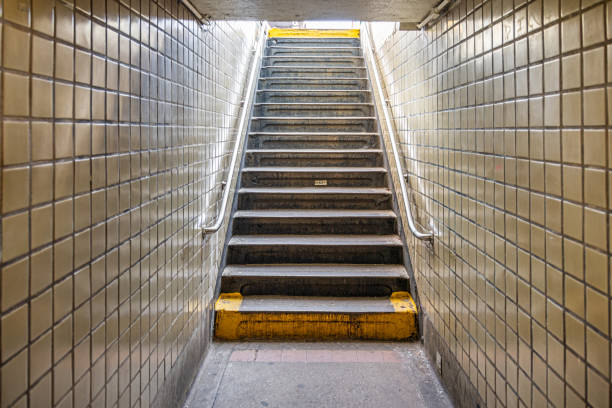 Stairs leading from a subway station to the street Stairs leading up to the street from an underground subway station. The photograph is taken at the Fulton Street underground subway station in Brooklyn, New York stair rail in new york city stock pictures, royalty-free photos & images