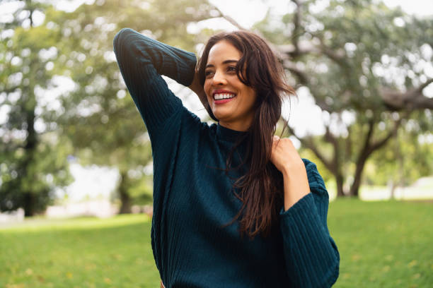 istock Smiling Woman Relaxing Outdoors in a Green Park Setting 2199083648