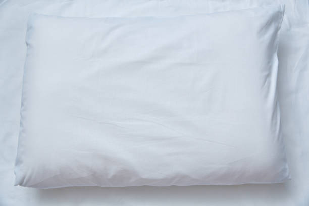 istock Top view of a white pillow against a white sheet. Copy space. 2199085956