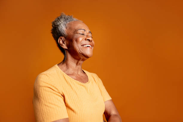 istock Senior woman with eyes closed on a orange background 2199087570
