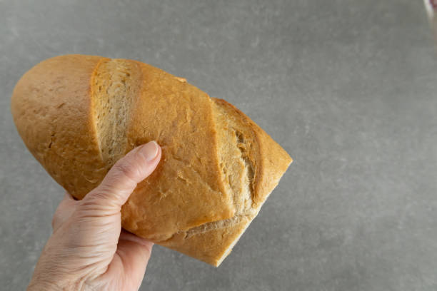 istock hand holding freshly baked bread loaf 2199088148