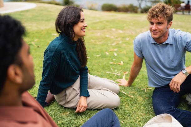 istock Friends Sitting on Grass in a Park Enjoying Conversation and Relaxing 2199088297