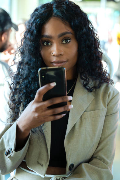 istock Young happy African American woman browsing the Internet with smart mobile application Vertical 2199090420