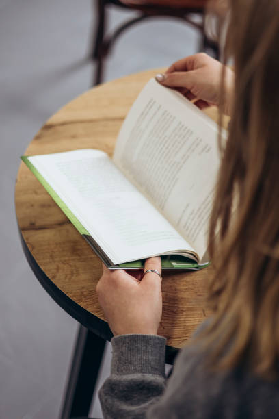 istock Female student in college library with book. Education and reading concept. 2199091362