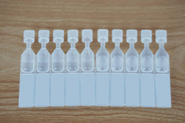 Single use artificial tear lubricant eye drops containers, tubes, isolated on brown background.  Concept, medical products for dry eyes or eyes disease treatment.