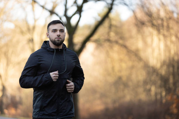 istock A young man is training by running in park surrounded by autumn trees 2199100037