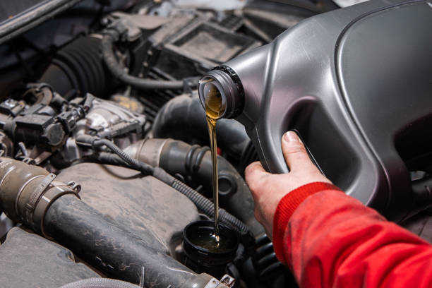istock Mechanic Pouring Fresh Engine Oil into Car Engine During Vehicle Maintenance 2199102639