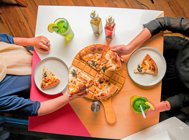 Girls sharing authentic italian style brick oven baked pizza.