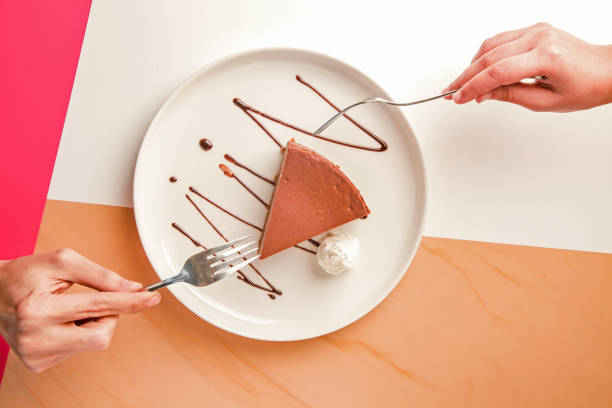 istock Friends sharing a slice of Chocolate cheese cake served with cream top angle. 2199103132
