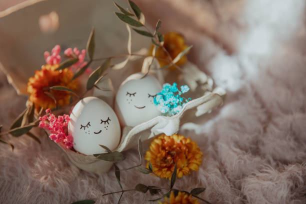 istock Two eggs with eyes in love with flowers on a fluffy background, Easter card 2199106232
