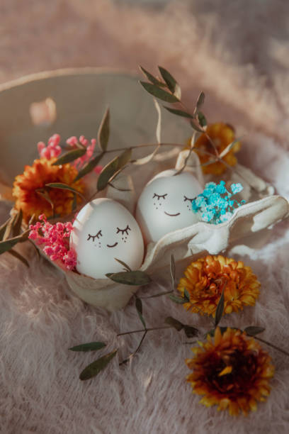 istock Two eggs with eyes in love with flowers on a fluffy background, Easter card 2199106354