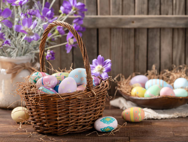 istock Easter eggs in a basket and bowl with purple daisies 2199108735