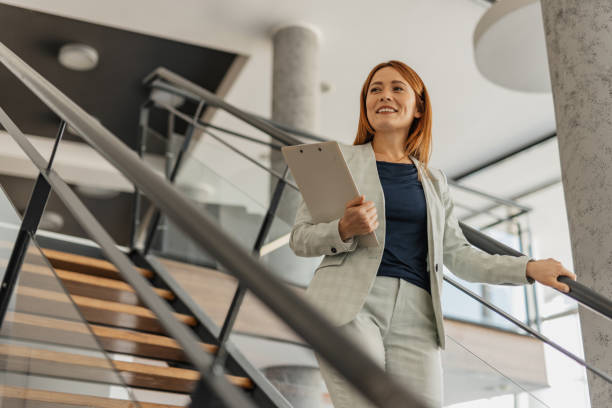 istock Confident Businesswoman Smiling on Office Staircase 2199108832