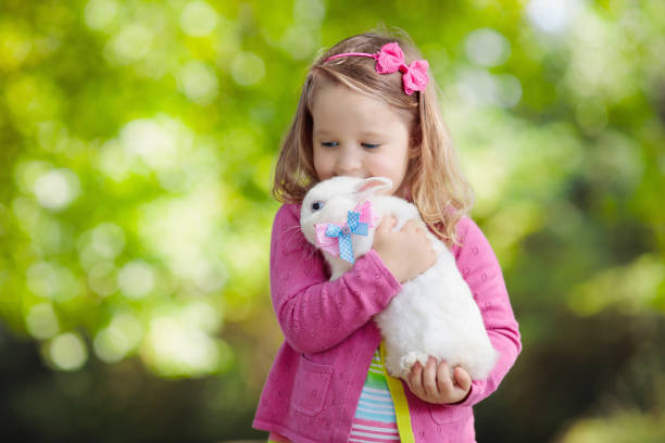 istock Little girl playing with rabbit 2199110965