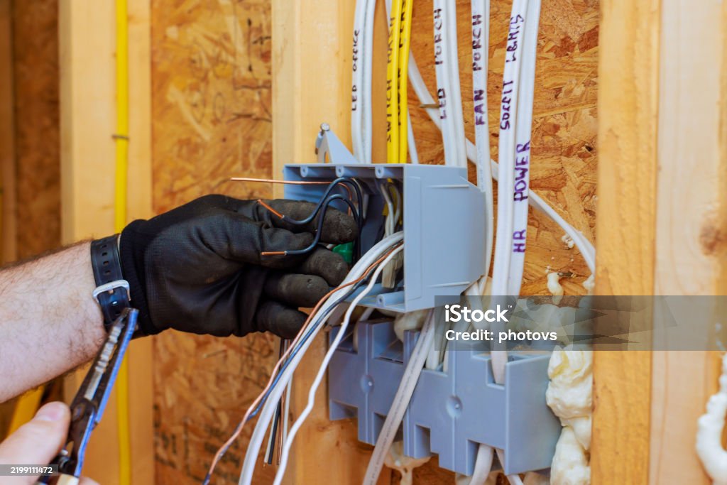 Electrician working on circuit box installation during home renovation project in a residential area - Royalty-free Eletricidade Foto de stock Electrician working on circuit box installation during home renovation project in a residential area - Royalty-free Eletricidade Foto de stock