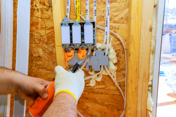 istock Electrician performs wiring installation in newly constructed wooden building 2199111480