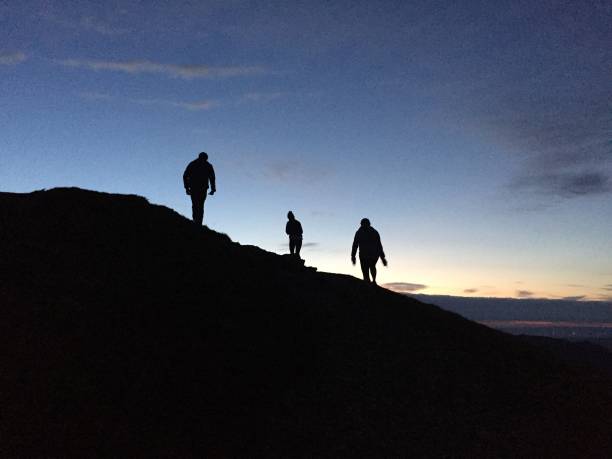 istock Silhouette figures on top of a mountain 2199112000