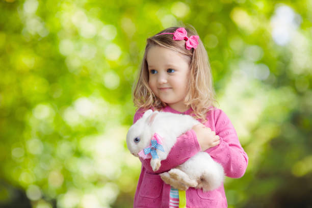 istock Little girl playing with rabbit 2199112028