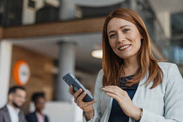 istock Happy woman posing while holding smartphone. 2199112049