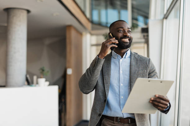 istock Smiling man in a gray suit talking on the phone 2199112557