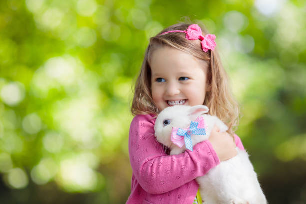 istock Little girl playing with rabbit 2199114932