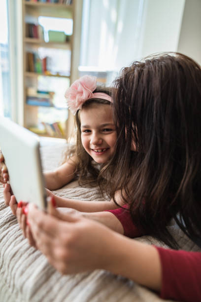 istock mom and daughter using the tablet at home 2199115895
