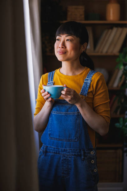 istock Woman drinking coffee while relaxing at home 2199116833