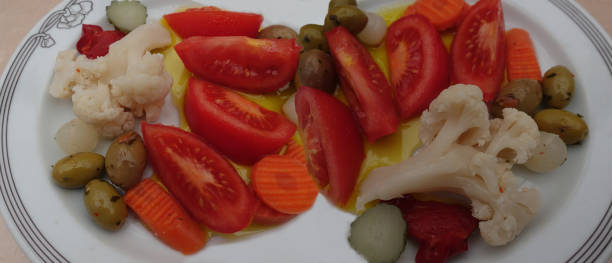 istock Appetizer buffet Assorted pickled vegetables and tomato portions drizzled with olive oil 2199117820