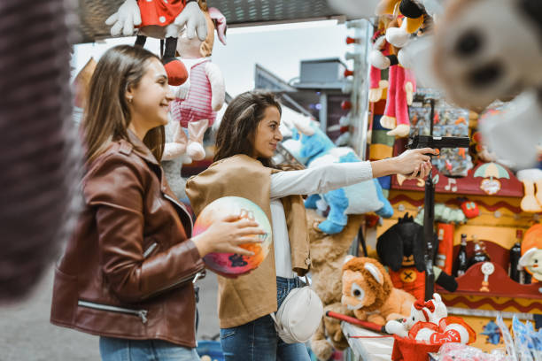 istock Focused Female Aiming Target Holding Gun While Friend is Waiting to See Result 2199119177