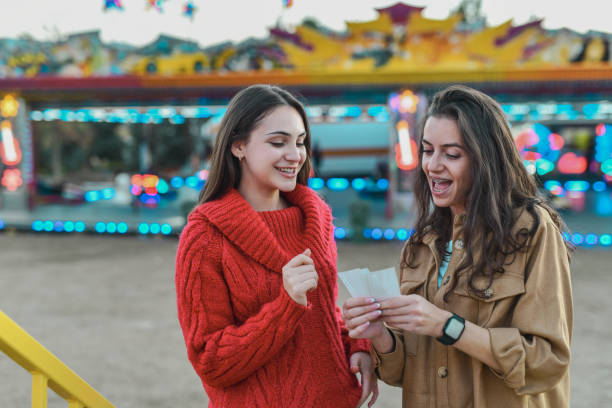 istock Caring Female Surprising Sister With Tickets For Amusement Park Rides 2199119630